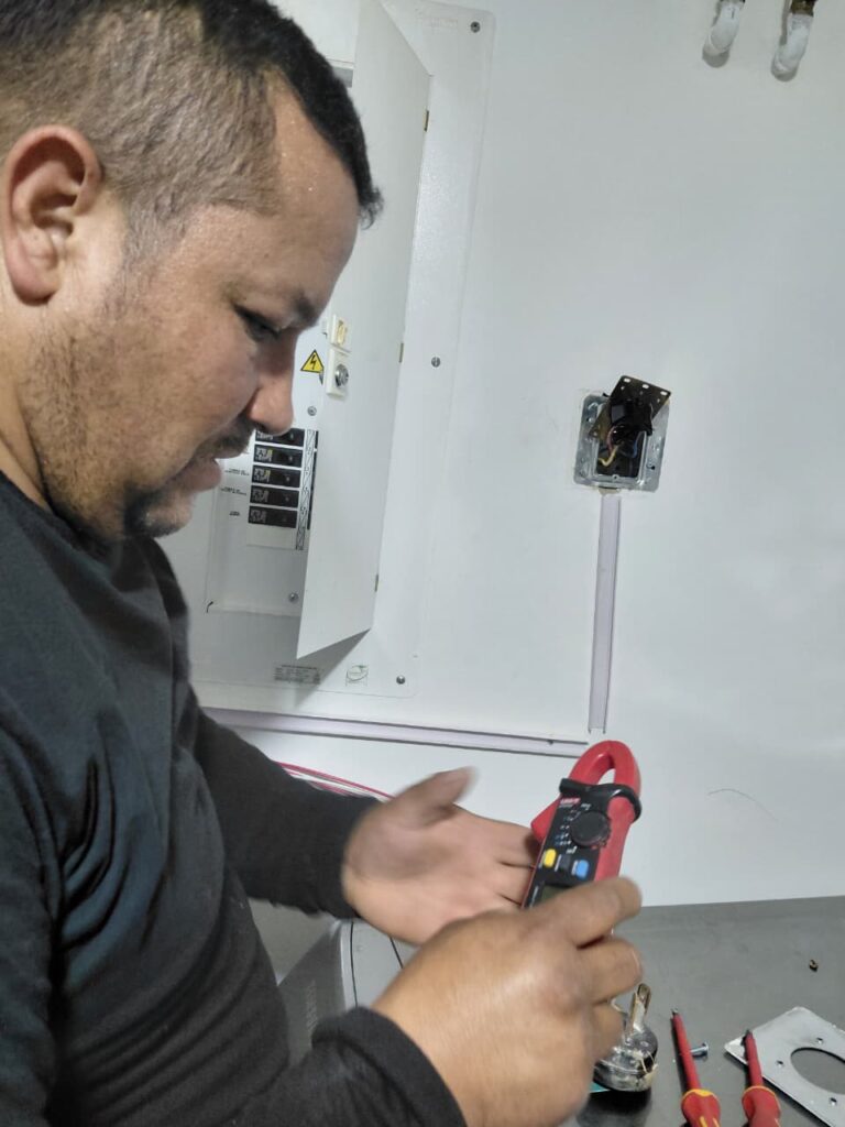 Técnico de W&W revisando una instalación eléctrica con multímetro